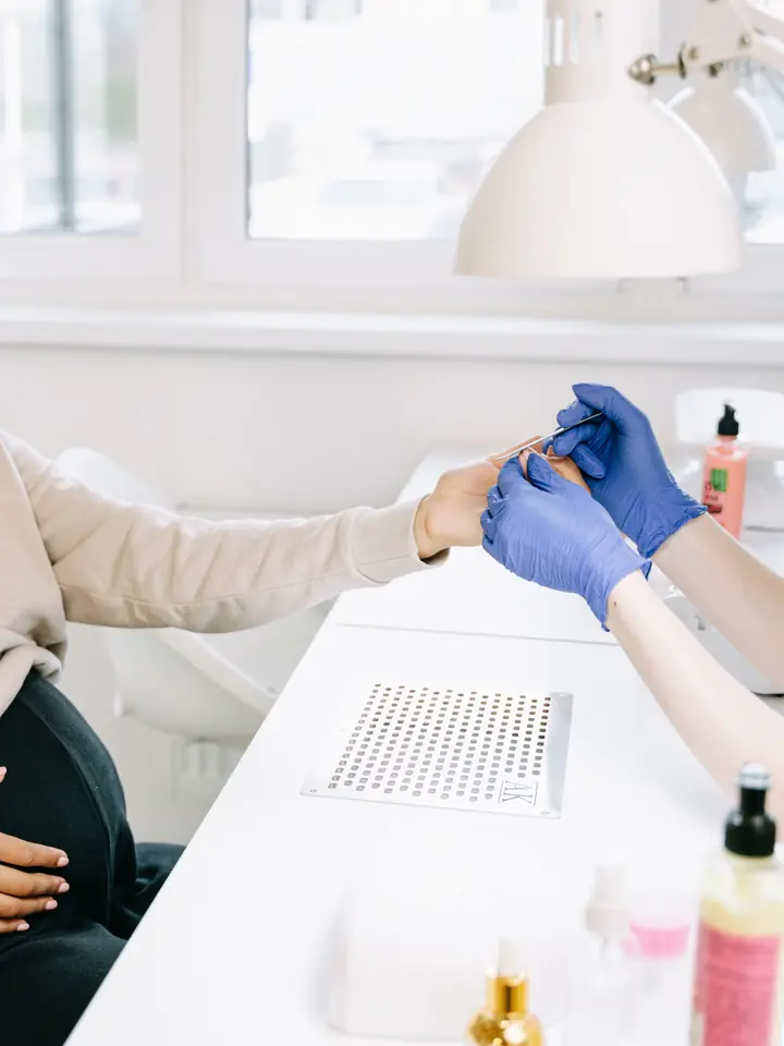 Client smiling during a manicure at a bright nail salon